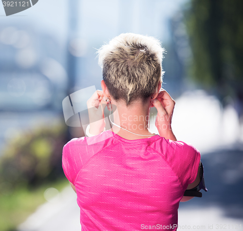 Image of jogging woman setting phone before jogging