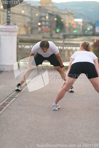 Image of couple warming up before jogging