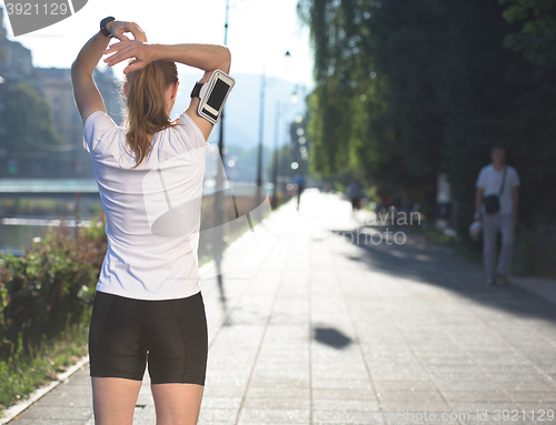 Image of blonde woman  stretching before morning jogging