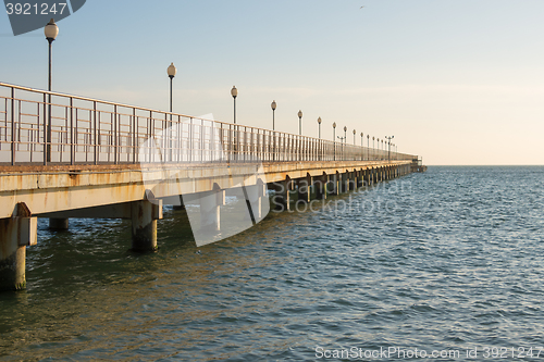 Image of View of the sea pier stretching into the distance at sunset