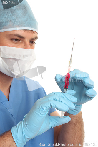 Image of Surgeon preparing checking needle syringe