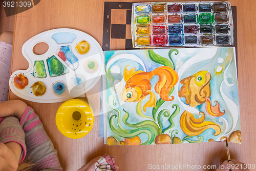 Image of Top view on a table behind which painted watercolor on paper goldfish