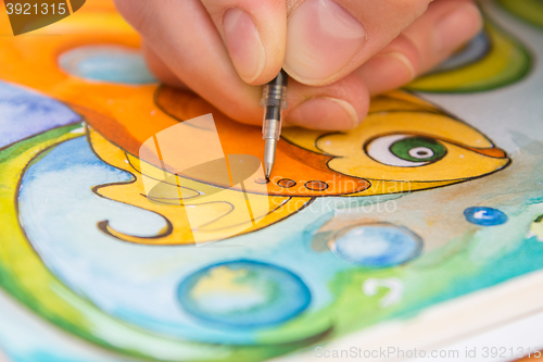 Image of Close-up of the process of drawing goldfish