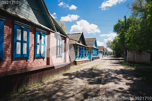 Image of one-storey houses stand along the road in the village