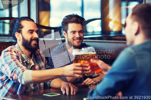 Image of happy male friends drinking beer at bar or pub