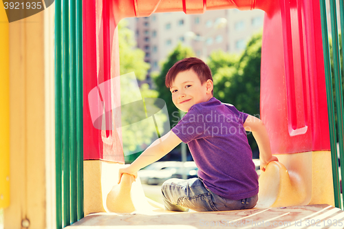 Image of happy little boy on slide at children playground