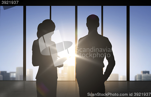 Image of silhouettes of business partners over office