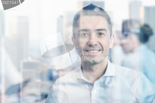 Image of group of smiling businesspeople meeting in office
