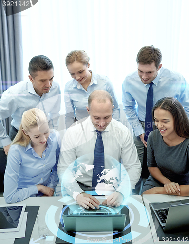 Image of smiling business people with laptop in office