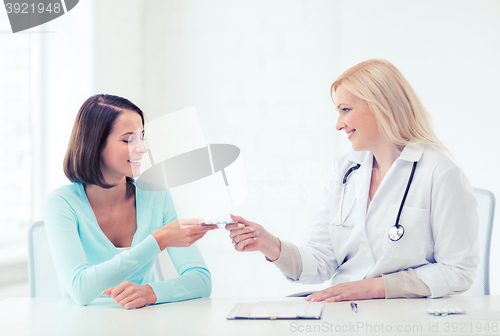 Image of doctor giving tablets to patient in hospital