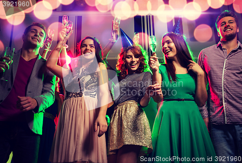 Image of smiling friends with glasses of champagne in club