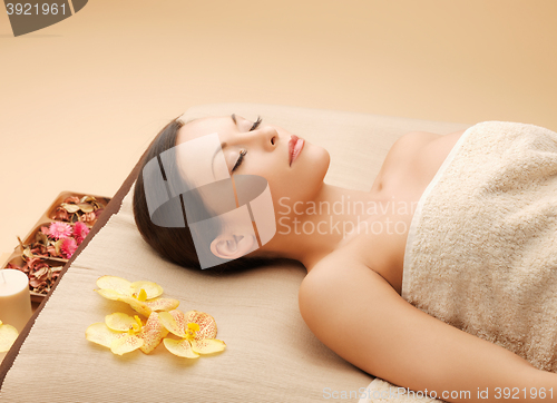 Image of woman in spa salon lying on the massage desk