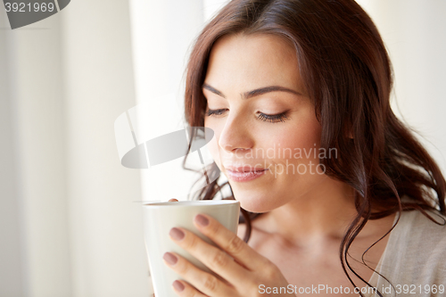 Image of happy woman with cup of tea or coffee at home