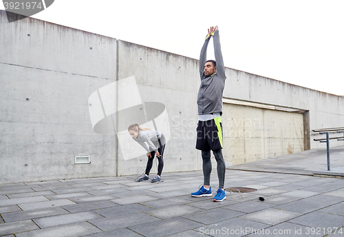 Image of tired couple stretching after exercise