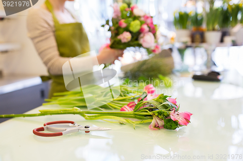 Image of close up of woman making bunch at flower shop