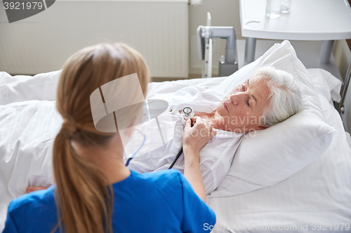 Image of nurse with stethoscope and senior woman at clinic