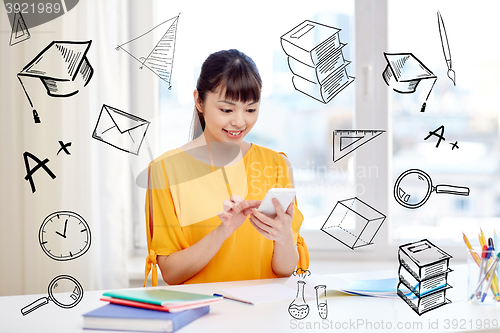 Image of happy young woman student with smartphone at home