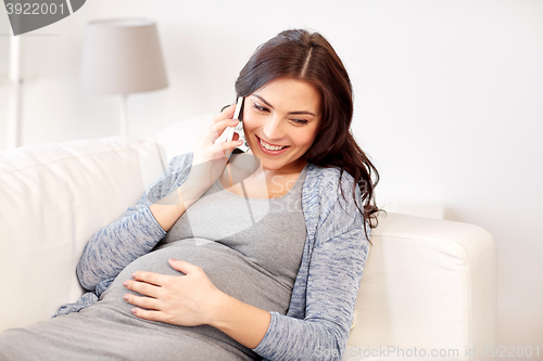 Image of happy pregnant woman calling on smartphone at home