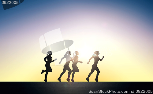 Image of happy young sports woman running outdoors