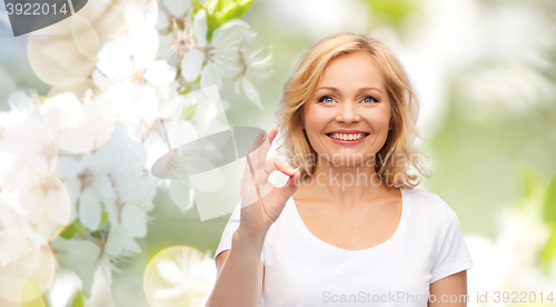 Image of happy woman in white t-shirt showing ok hand sign