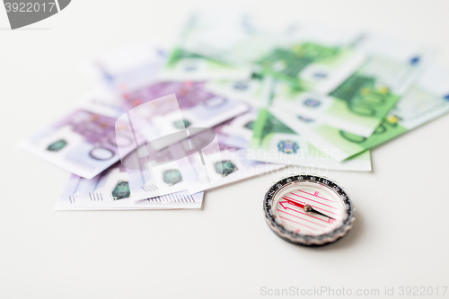 Image of close up of compass and euro money on table