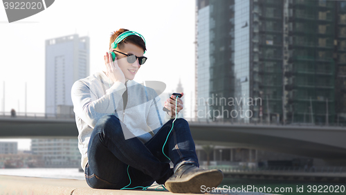 Image of happy young man in headphones with smartphone