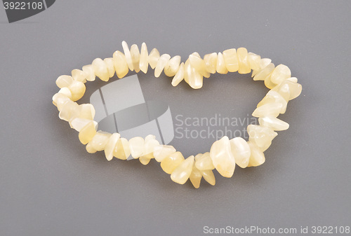 Image of Splintered orange calcite chain on gray background