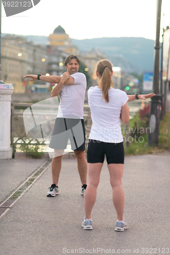 Image of couple warming up before jogging