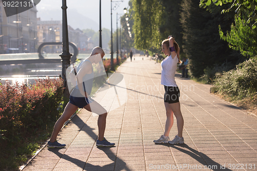 Image of couple warming up and stretching before jogging