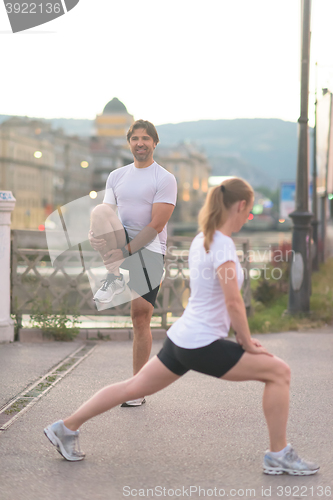 Image of couple warming up before jogging