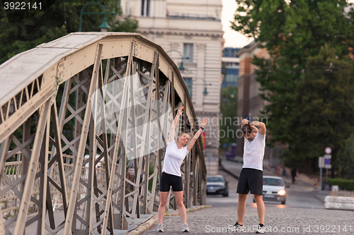 Image of couple warming up and stretching before jogging