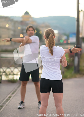 Image of couple warming up before jogging