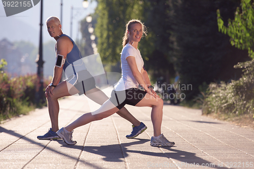 Image of couple warming up and stretching before jogging