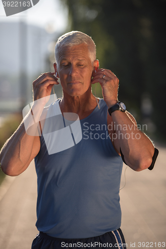 Image of portrait of handsome senior jogging man