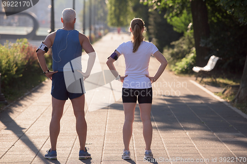 Image of jogging couple planning running route  and setting music