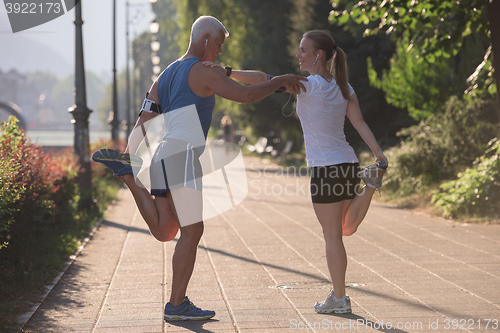 Image of couple warming up and stretching before jogging