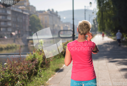 Image of jogging woman setting phone before jogging