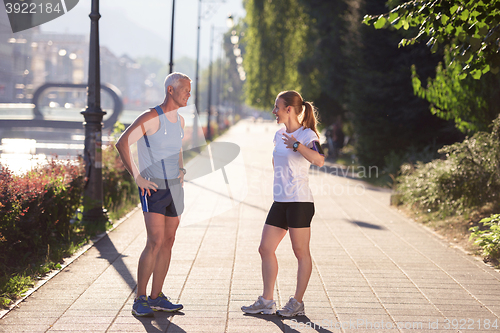 Image of couple warming up and stretching before jogging