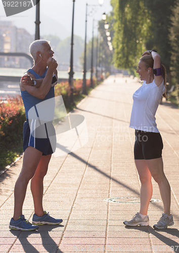 Image of couple warming up and stretching before jogging