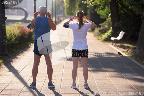 Image of jogging couple planning running route  and setting music