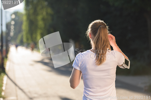 Image of jogging woman setting phone before jogging