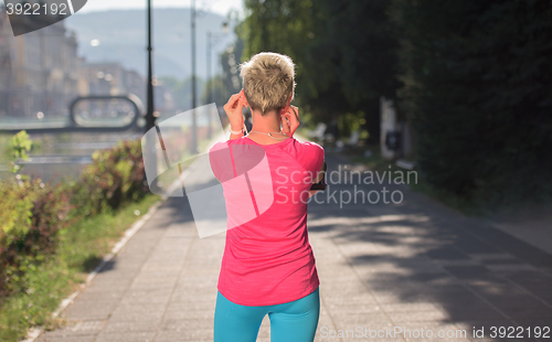 Image of jogging woman setting phone before jogging