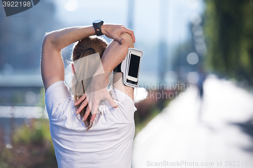Image of blonde woman  stretching before morning jogging