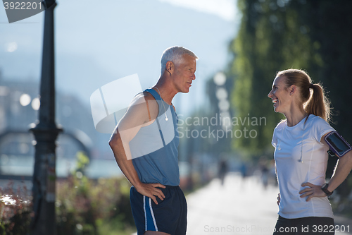 Image of jogging couple planning running route  and setting music