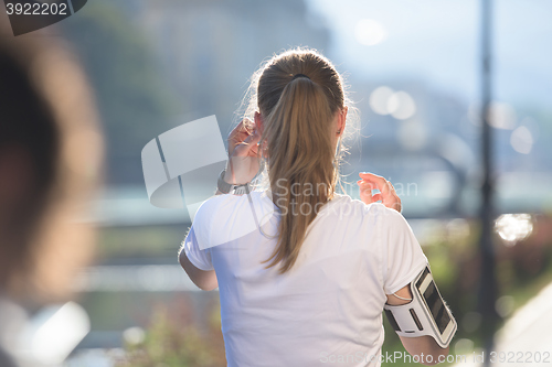 Image of jogging woman setting phone before jogging