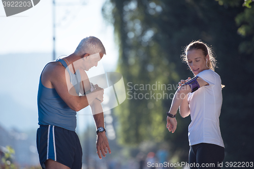 Image of jogging couple planning running route  and setting music