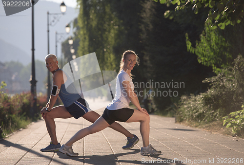 Image of couple warming up and stretching before jogging