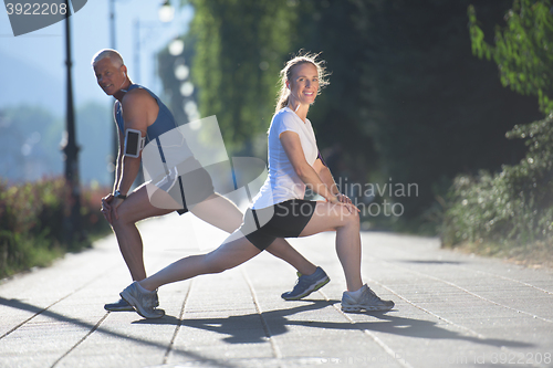 Image of couple warming up and stretching before jogging