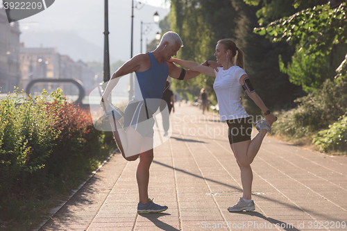 Image of couple warming up and stretching before jogging