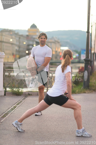 Image of couple warming up before jogging